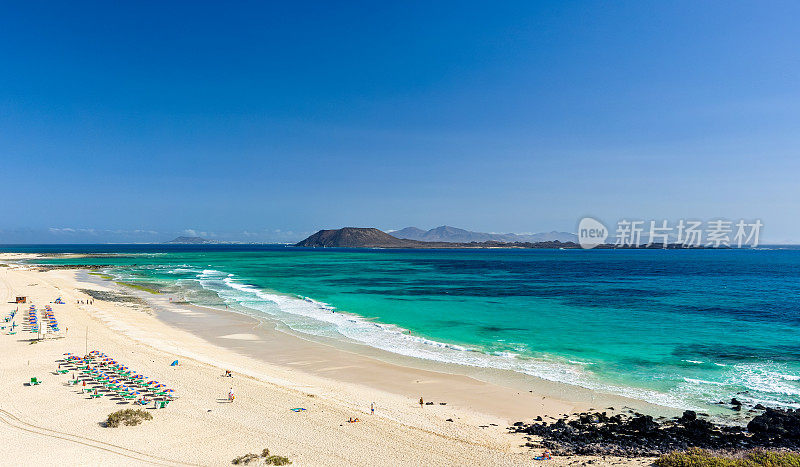 从加那利群岛富尔特文图拉的Corralejo海滩(Grandes Playas de Corralejo)看到的Lobos和Lanzarote岛的XXL全景图。美丽的绿松石水和白色的沙子。
